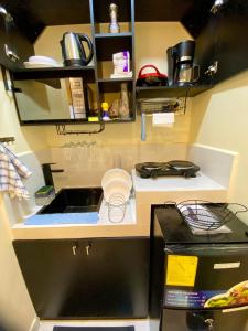 a small kitchen with a sink and a stove at Microsuite 2 hermosa y céntrica in Guayaquil +9 photos