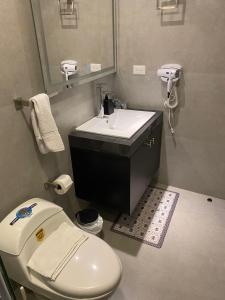 a bathroom with a white toilet and a sink at Microsuite 2 en Guayaquil elegante y privada in Guayaquil