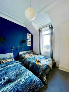 a bedroom with two beds and a window at Cosy stylish Dumbarton flat in Dumbarton