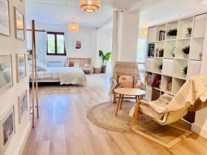 sala de estar con cama y habitación con silla en Loft entre mer et campagne à 5 min d'Ajaccio classé 4 étoiles, en Alata