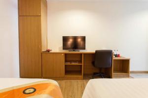 a room with a desk with a television and a chair at The Sita Princess in Buriram