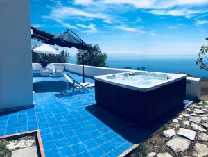 uma banheira de hidromassagem num pátio com vista para o oceano em Villa Nettuno Sorrento - Amalfi Coast em Sorrento