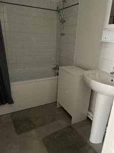uma casa de banho com um lavatório, uma banheira e um WC. em Appartement spacieux et cosy 20 min to Paris & JO 2024 em Sannois