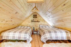a bedroom with two beds in a log cabin at Secluded Brevard Cabin with Private Waterfall! in Lake Toxaway