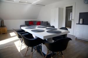 einen weißen Tisch mit schwarzen Stühlen im Wohnzimmer in der Unterkunft Apartamenty Taternickie in Zakopane