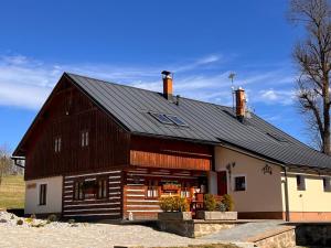 a large barn with a black roof at Chalupa Chřiby in Deštné v Orlických horách