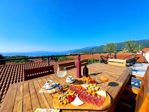 - une table en bois avec de la nourriture et des verres de vin dans l'établissement Holiday Home Fiori, à Kastav