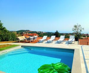 une piscine avec des chaises longues sur le toit dans l'établissement Holiday Home Fiori, à Kastav