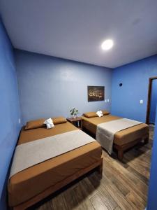 two beds in a room with blue walls at LA CASA AZUL DE SAMARA in Barrio Nuevo