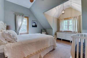 1 dormitorio con 1 cama blanca y algunas ventanas en Golden Dream on Lake Muskoka, en Gravenhurst