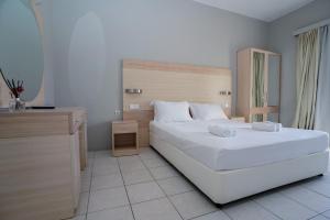 1 dormitorio con 1 cama blanca grande y escritorio en Alexandros Studios Moraitika en Moraitika