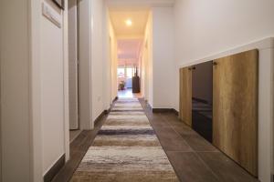 - un couloir avec des murs blancs et un tapis au sol dans l'établissement Apartman BOJANA, à Pirot