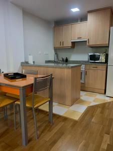 cocina con mesa, sillas y nevera en Apartamento en Unquera, en Unquera
