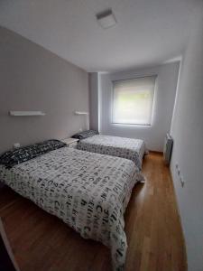 two beds in a room with a window at Apartamento en Unquera in Unquera