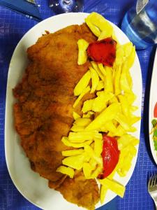 a plate of food with meat and pasta on a table at Su3ño Cántabro apto en Unquera in Unquera
