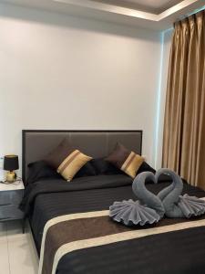 a bed with two swans in the shape of a heart at Condo Arcadia Beach jomtien pattaya in Pattaya South +47 photos
