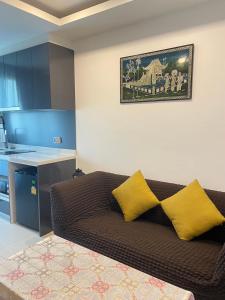 a living room with a couch with yellow pillows at Condo Arcadia Beach jomtien pattaya in Pattaya South