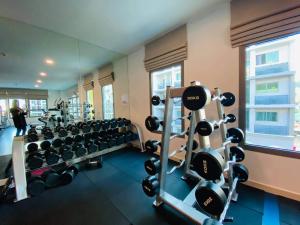 a gym with several rows of weights at Condo Arcadia Beach jomtien pattaya in Pattaya South