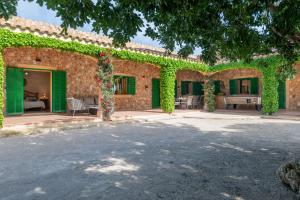 un bâtiment recouvert de lierre vert avec une cour dans l'établissement Finca Girasols, à Campos