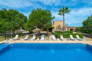 a swimming pool with lounge chairs and umbrellas at Finca Girasols in Campos