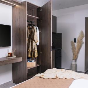 Alcyone Studios and Apartments في مدينة هيراكيلون: غرفة نوم بدولاب خشبي وسرير