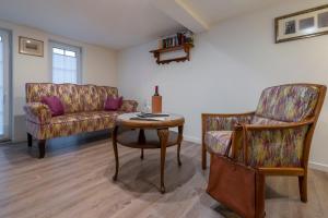 ein Wohnzimmer mit einem Sofa, einem Tisch und einem Stuhl in der Unterkunft Anduns exklusive Scheune in Boppard