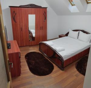 シビウにあるVila dintre braziのベッドルーム(ベッド1台、鏡付)