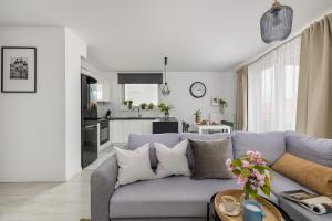a living room with a blue couch and a kitchen at TS Hello City Apartment in Szczecin