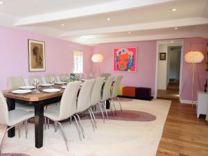 uma sala de jantar com uma mesa e cadeiras brancas em 6 Bed in Wroxham 72652 em Hoveton