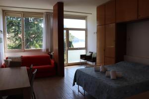 a living room with a bed and a red couch at Beautiful lake in Garda