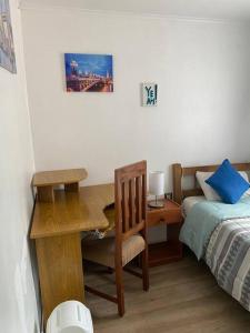 - une chambre avec un bureau, un lit, un bureau et un sèche-cheveux dans l'établissement Dulces Sueños, à Chillán