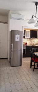 eine Küche mit einem Kühlschrank aus Edelstahl und einem Tisch in der Unterkunft La casa di Viola in Rom