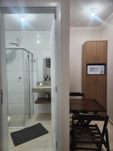 a small kitchen with a table and a microwave at Inspire GuestHouse in Campos do Jordão