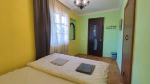 a bedroom with a bed with two towels on it at The Friends in Kutaisi