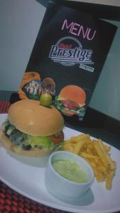 a plate with a sandwich and fries and a bowl of dipping sauce at Prestige Motel 3 in São Paulo