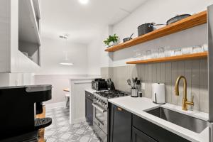 una cocina con estufa y fregadero en SoHo Siesta Stunning Apt w Private Balcony, en Tampa