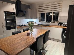 a kitchen with a wooden table and black chairs at LT Apartments Stoneygate - 2 Bed in Leicester
