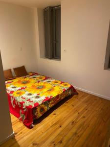 - une chambre avec un lit doté d'une couette colorée dans l'établissement Bastide centre, à Carcassonne