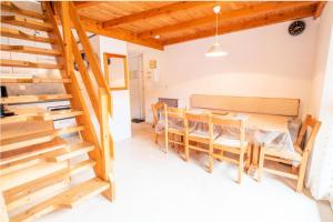 a dining room with a table and wooden stairs at Résidence Les Arolles - 3 Pièces pour 8 Personnes 193175 in Villarodin-Bourget