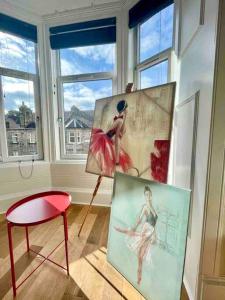 a room with two paintings and a chair and a table at Dumbarton cosy home, Loch Lomond in Dumbarton