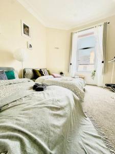 a white room with two beds and a window at Dumbarton cosy home, Loch Lomond in Dumbarton
