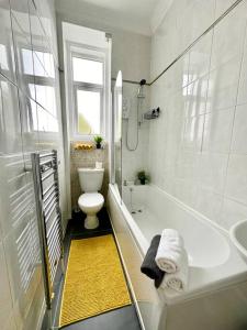 a bathroom with a tub and a toilet and a sink at Dumbarton cosy home, Loch Lomond in Dumbarton