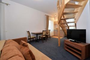 a living room with a couch and a table with a television at Guest House & Villa Astoma in Palanga