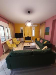 sala de estar con sofá verde y sillas amarillas en K & R apartment, 