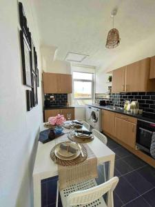 a kitchen with a table and chairs in a room at Dumbarton cosy home, Loch Lomond in Dumbarton