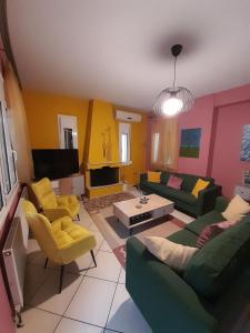 sala de estar con sofás verdes y TV en K & R apartment, 