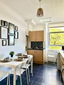 Dumbarton cosy home, Loch Lomond في دمبارتون: مطبخ مع طاولة وكراسي في غرفة