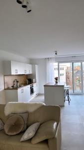 Il comprend un salon avec un canapé et une cuisine. dans l'établissement Joli appartement haut standing Liège Centre, à Liège