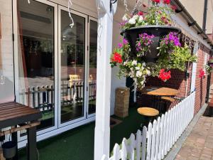 a patio with tables and flowers on a building at Garden Cottage at Old Post Office in Bardon Mill