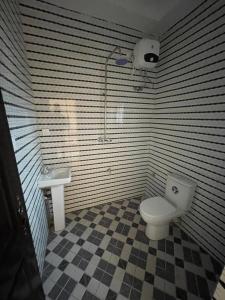 a bathroom with a toilet and a sink at CasaCasa Apartments in Enugu